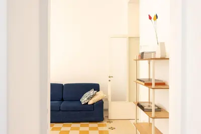a blue couch sitting in a living room at Colosseo Apartment - Domus Claudinae in Rome