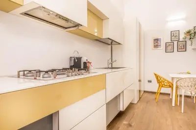 a kitchen with white countertops and a dining table at Cozy Rome - Newly Renovated Apartment near Vatican City in Rome