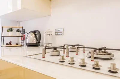 a white kitchen counter with a stove top oven at Cozy Rome - Newly Renovated Apartment near Vatican City in Rome