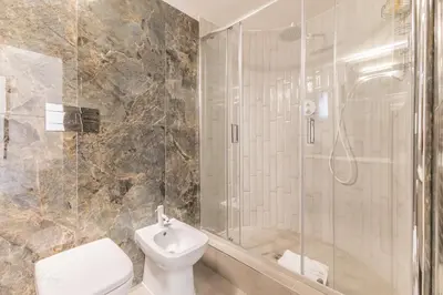 a bathroom with a shower and a toilet and a sink at Cozy Rome - Newly Renovated Apartment near Vatican City in Rome