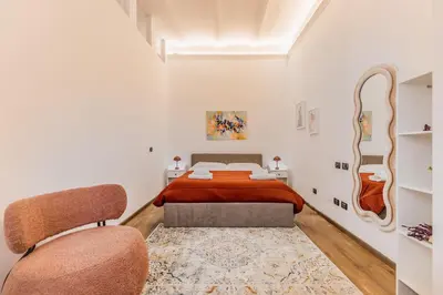 a bedroom with a bed and two chairs at Cozy Rome - Newly Renovated Apartment near Vatican City in Rome