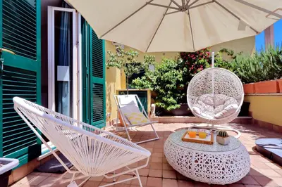 a patio with two chairs and a table and an umbrella at Vico Rooms and Terrace in Rome