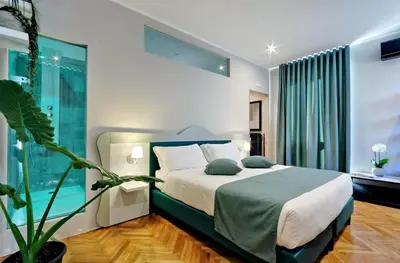 a bedroom with a bed and a potted plant at Vico Rooms and Terrace in Rome