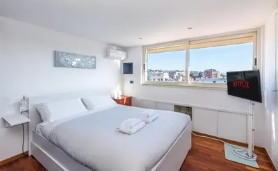 a bedroom with a white bed and a window at Vaticano-Metro A, Penthouse with AC, Wi-Fi e Netflix in Rome