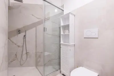 a white bathroom with a shower and a toilet at Coppelle Charme in Rome