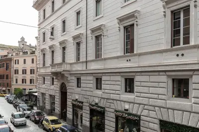 a large white building with cars parked on a street at Coppelle Charme in Rome