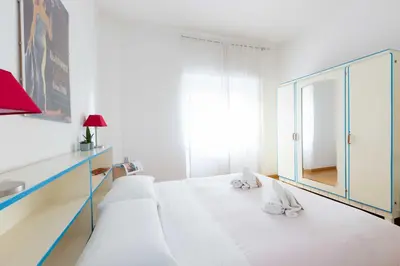 a white bedroom with a large white bed with a mirror at Casa Emiliani Ospedale San Camillo - Cale 09 in Rome
