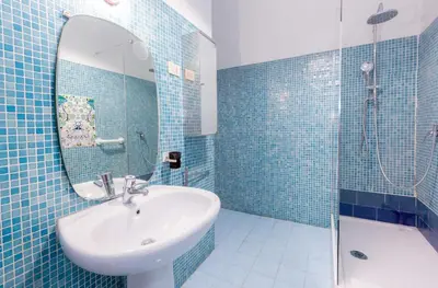 a blue tiled bathroom with a sink and a shower at Casa Emiliani Ospedale San Camillo - Cale 09 in Rome