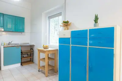 a kitchen with blue cabinets and a table at Casa Emiliani Ospedale San Camillo - Cale 09 in Rome