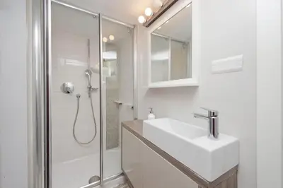 a white bathroom with a sink and a shower at Beautiful Monti apartment Panisperna in Rome