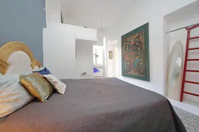 a bedroom with a bed and a painting on the wall at Beautiful Monti apartment Panisperna in Rome