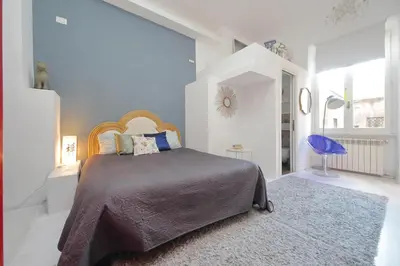 a bedroom with a bed and a blue wall at Beautiful Monti apartment Panisperna in Rome
