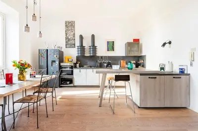 a kitchen with white cabinets and a table and chairs at Principe House, Central Rome, 3 bedroom 2 bath, Elegant Apartment full of Light in Rome