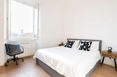 a bedroom with a bed and a chair and a window at Principe House, Central Rome, 3 bedroom 2 bath, Elegant Apartment full of Light in Rome