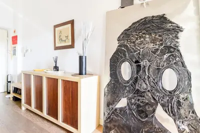 a painting of a mask on the wall in a room at Principe House, Central Rome, 3 bedroom 2 bath, Elegant Apartment full of Light in Rome