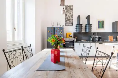 a kitchen with a wooden table with a vase of flowers at Principe House, Central Rome, 3 bedroom 2 bath, Elegant Apartment full of Light in Rome