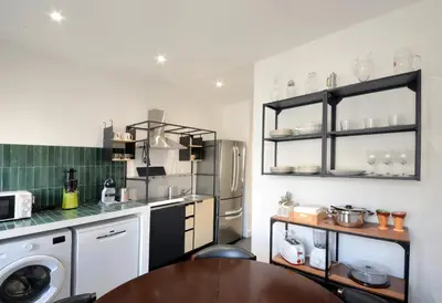 a kitchen with a table and a refrigerator at Led House Roma in Rome
