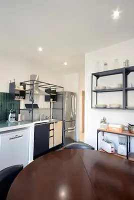 a kitchen with a wooden table and a refrigerator at Led House Roma in Rome