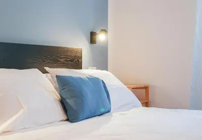 a blue pillow sitting on top of a white bed at 50mt Metro Station - 20min walking from Colosseum - RomeCentralHouse - Elegant and fully equipped in Rome