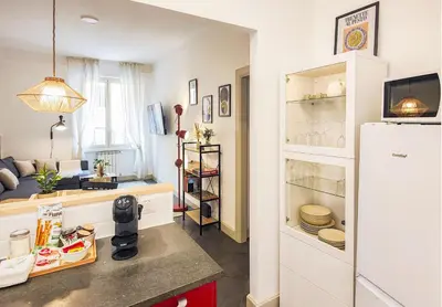 a kitchen with a refrigerator and a living room at 50mt Metro Station - 20min walking from Colosseum - RomeCentralHouse - Elegant and fully equipped in Rome
