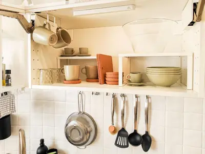 a kitchen with utensils on a shelf at 50mt Metro Station - 20min walking from Colosseum - RomeCentralHouse - Elegant and fully equipped in Rome
