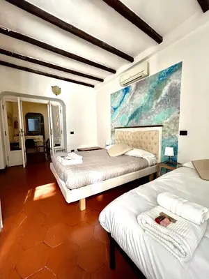 a bedroom with two beds and a painting on the wall at Cellini apartments in Rome