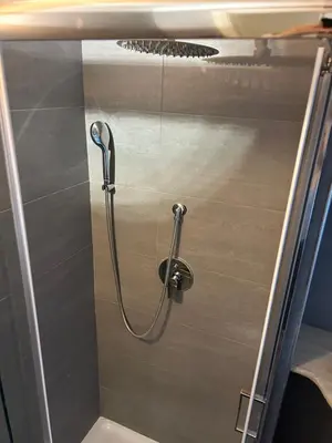 a shower with a hose on a wall in a bathroom at Cellini apartments in Rome