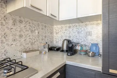 a kitchen with white cabinets and a counter top at Emanuele Filiberto - Vivora Srl in Rome