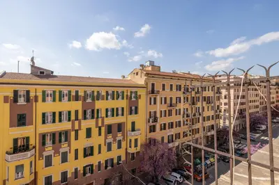 a yellow building with a parking lot in front of it at Emanuele Filiberto - Vivora Srl in Rome