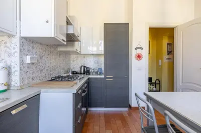 a kitchen with white cabinets and a counter top at Emanuele Filiberto - Vivora Srl in Rome