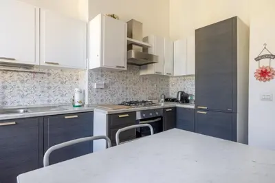 a kitchen with white cabinets and a table with chairs at Emanuele Filiberto - Vivora Srl in Rome