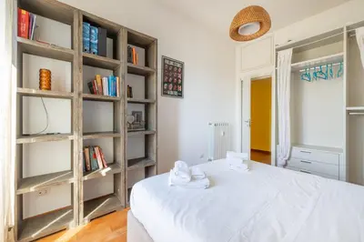 a room with a white bed and a book shelf at Emanuele Filiberto - Vivora Srl in Rome