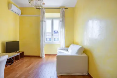 a room with a white chair and a window at Emanuele Filiberto - Vivora Srl in Rome