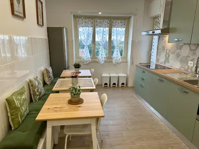 a kitchen with three tables and a kitchen with a counter at Monti Tiburtini Roma Guest House Apartment in Rome