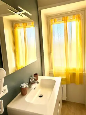 a bathroom with a sink and a mirror and a window at Monti Tiburtini Roma Guest House Apartment in Rome