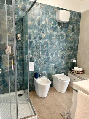 a bathroom with a shower and a toilet and a sink at Monti Tiburtini Roma Guest House Apartment in Rome