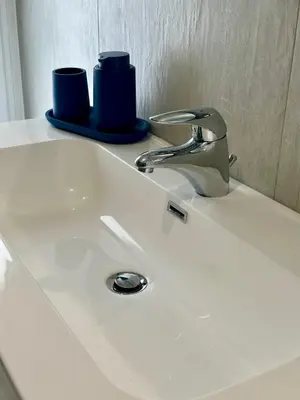 a bathroom sink with a faucet and two cups on it at Monti Tiburtini Roma Guest House Apartment in Rome