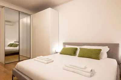 a bedroom with a large white bed with green pillows at Floresa Vatican Elite in Rome