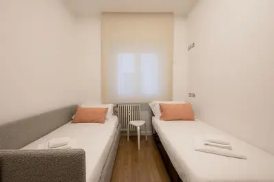 a small room with two beds and a chair at Floresa Vatican Elite in Rome