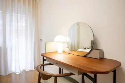 a dressing table with a mirror and a lamp on it at Floresa Vatican Elite in Rome