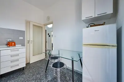 a kitchen with a glass table and a refrigerator at Modern Comfort Steps from Tiburtina Station in Rome