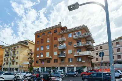 a parking lot with cars parked in front of a building at Modern Comfort Steps from Tiburtina Station in Rome