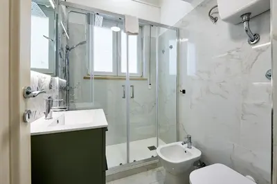 a bathroom with a shower and a sink and a toilet at Modern Comfort Steps from Tiburtina Station in Rome
