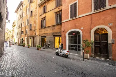 a scooter parked on a cobblestone street next to buildings at Home-In-Rome in Rome
