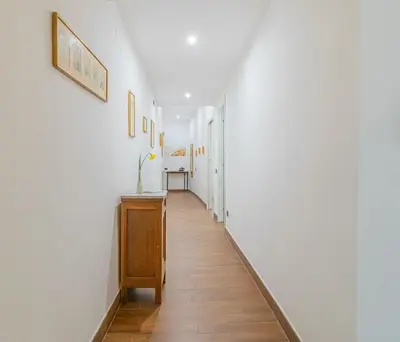 a hallway with white walls and a wooden floor at Home relax San Lorenzo in Rome