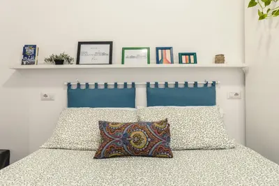 a bed with a blue headboard and two pillows at Br1tannia 36 in Rome