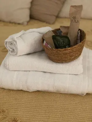 a basket of towels sitting on top of a stack of towels at Casa Umbertina in Rome
