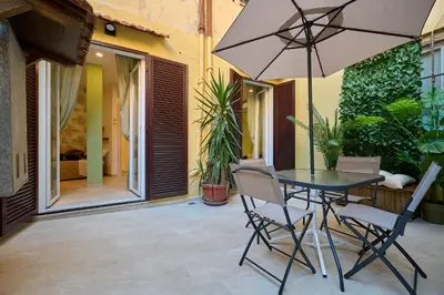 a table and chairs with an umbrella on a patio at SweetgardenTrastevere in Rome