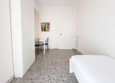 a white room with a bed and a table at Vintage Charm & Comfort - Garbatella in Rome