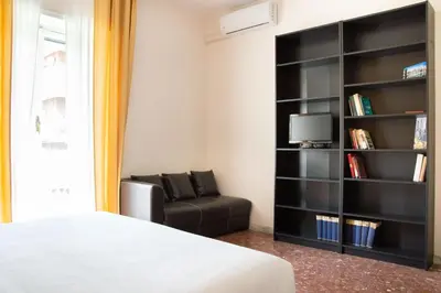 a bedroom with a chair and a book shelf at Vintage Charm & Comfort - Garbatella in Rome